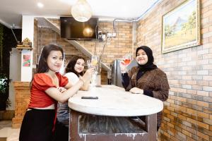 a group of three women standing around a counter with wine glasses at Agatha Canggu in Canggu