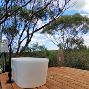 une baignoire blanche installée au-dessus d'une terrasse en bois dans l'établissement Strandmarken, à Island Beach