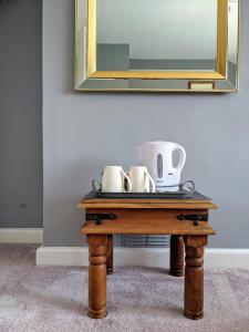 a table with two coffee cups and a mirror at Cottars in Winfrith Newburgh