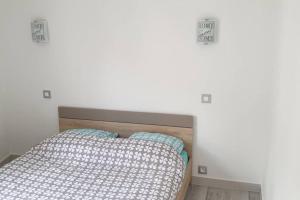 ein Bett in einem Zimmer mit einer weißen Wand in der Unterkunft Maison de ville Angoulêmoise in Angoulême + 5 Fotos