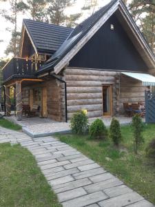 a log cabin with a black roof and a patio at Baltic Dream in Rozewie