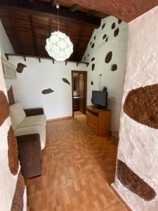 a living room with a couch and a tv at Palmera 16 in Santa Lucía