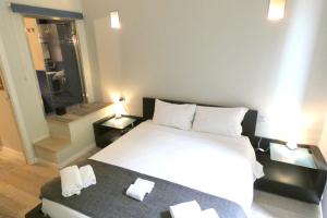um quarto com uma grande cama branca com duas mesas de cabeceira em Heart Milan Apartments Centrale em Milão