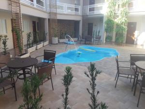 a swimming pool in a room with tables and chairs at Casagrande Olímpia Hotel in Olímpia