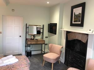 a bedroom with a fireplace and a bed and a desk at Mount Street House in Brecon