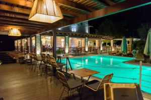 un restaurante con piscina por la noche en Bacchus en Olympia