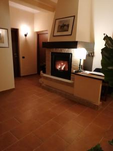 Passo CoreseにあるLe Vecchie Scuderieの暖炉とランプ付きのリビングルーム
