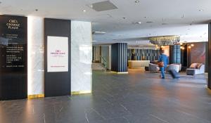 a lobby with a person walking in a building at Crowne Plaza Helsinki - Hesperia, an IHG Hotel in Helsinki