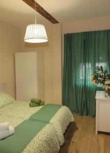 1 dormitorio con 1 cama y cortina verde en Casa del maestro, en Orbita