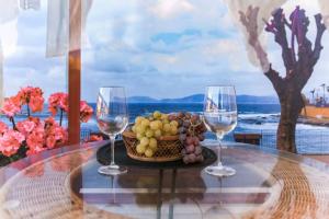 a table with two wine glasses and a basket of fruit at Delizioso appartamento ad Alghero in Alghero