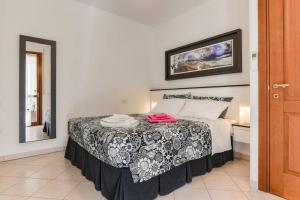 a bedroom with a bed with a black and white comforter at Delizioso appartamento ad Alghero in Alghero