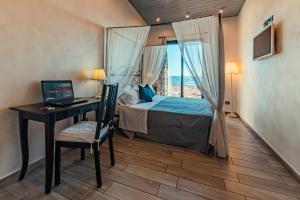 a bedroom with a bed and a desk with a laptop at B&B Marranzano in Giardini Naxos