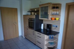 uma cozinha com um balcão preto e armários de madeira em Ferienhaus Englburg in absolut ruhiger Lage em Tittling