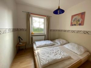 a bedroom with two beds and a window at Ferienwohnungen Zur alten Schule in Altenkirchen