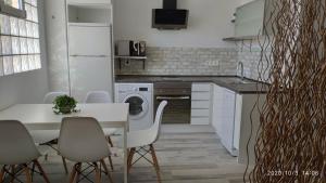 a kitchen with a white table and chairs and a kitchen with a washer at Apartamento La Luna in Lumpiaque