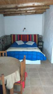 een slaapkamer met een bed en een tafel. bij Casa Tai - La Crucecita in Godoy Cruz