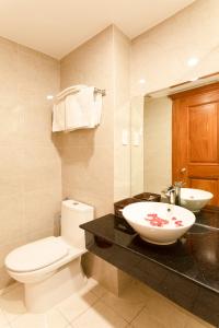 Łazienka z białą toaletą i umywalką w obiekcie Bao Son Hotel - Apartment w mieście Nha Trang