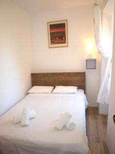 sypialnia z białym łóżkiem i 2 ręcznikami w obiekcie Apartment MONTE w Rovinj