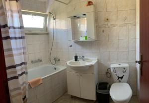 
a bathroom with a toilet, sink, and tub at Eko Penzion Leo in Dudince
