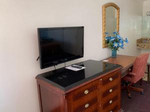 a desk with a tv and a chair in it at Americas Best Value Inn and Suites -Yucca Valley in Yucca Valley