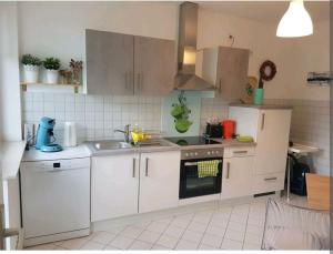 Nette,kleine Wohnung in gute Lage في إيسن: مطبخ مع دواليب بيضاء ومغسلة