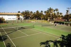 two people playing tennis on a tennis court at Casa Grande Hotel Resort & Spa in Guarujá