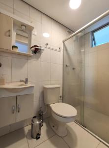 a bathroom with a toilet and a glass shower at Flat CasaSouza in Santa Maria