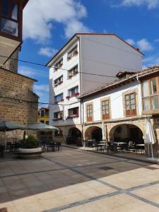 un edificio con tavoli e sedie in un cortile di El RINCON ESPINOSA a Espinosa de los Monteros