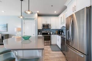 a kitchen with white cabinets and a stainless steel refrigerator at The Villas at Santa Rosa Beach in Santa Rosa Beach