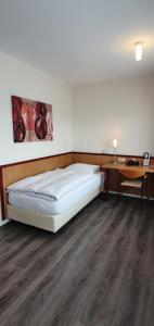 Cama en habitación con escritorio y cama sidx sidx sidx sidx en Hotel Hillegosser Hof, en Bielefeld