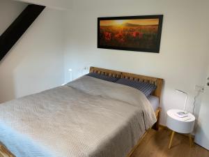 バート・ローテンフェルデにあるGala Apartment am Kurparkのベッドルーム1室(ベッド1台付)が備わります。壁に絵が飾られています。