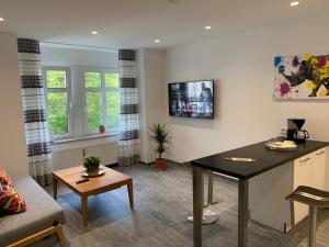 a living room with a table and a couch at Gala Apartment am Kurpark in Bad Rothenfelde