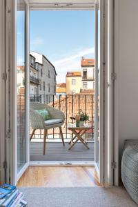 an open door to a balcony with a chair and a table at Jasmine Loft in Porto