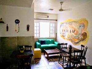 uma sala de estar com um sofá verde e uma mesa em Pousada Liras da Poesia em Porto de Galinhas