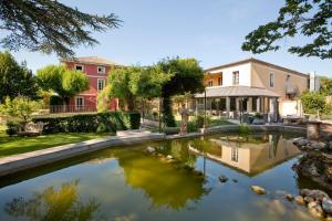 a pool of water in front of a building at Villa Augusta in Saint-Paul-Trois-Châteaux