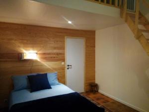 een slaapkamer met een bed met een houten muur bij L'App'Art des Ateliers Gerny in Humain