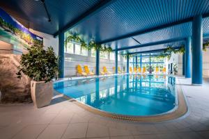 a swimming pool in a building with blue ceilings at Parkhotel zur Klause in Bad Hall