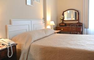 a bedroom with a bed and a mirror and a dresser at Hotel Palacio in Montevideo