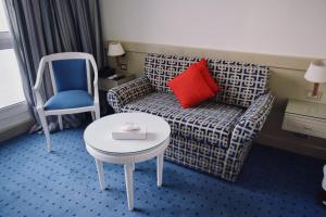 um quarto com um sofá, uma mesa e uma cadeira em Romance Alexandria Hotel em Alexandria