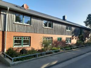 a red brick building with windows on a street at Ferienwohnung Hans & Elsa in Neudorf-Bornstein