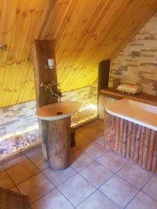 La salle de bains est pourvue d'un lavabo et d'une baignoire. dans l'établissement Babie lato ., à Brudnów