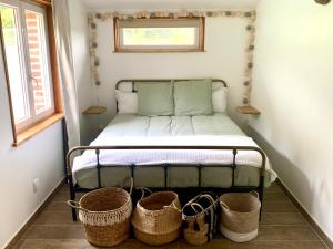 1 dormitorio pequeño con 1 cama con cestas en el suelo en Le gîte du bois Greffier en Flêtre