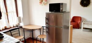 eine Küche mit einem Kühlschrank und einer Mikrowelle darüber in der Unterkunft Gyöngyvendégház in Szigetvár