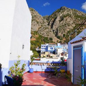 a balcony with blue and white buildings and a mountain at Dar Dalia in Chefchaouen