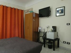 1 dormitorio con 1 cama y TV de pantalla plana en Le Pergole 21, en San Cataldo