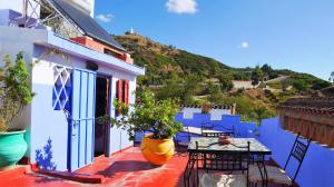 a blue and white house with a table and chairs at Dar Dalia in Chefchaouen