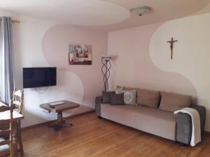 a living room with a couch and a cross on the wall at Apartments Angela in Wiesau