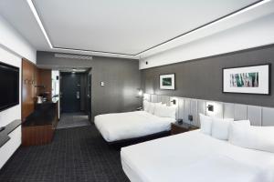 a hotel room with two beds and a flat screen tv at Hotel Bonaventure Montreal in Montreal