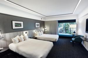 a hotel room with two beds and a window at Hotel Bonaventure Montreal in Montréal