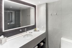 
a bathroom with a sink, mirror, and bath tub at Hotel Bonaventure Montreal in Montreal

